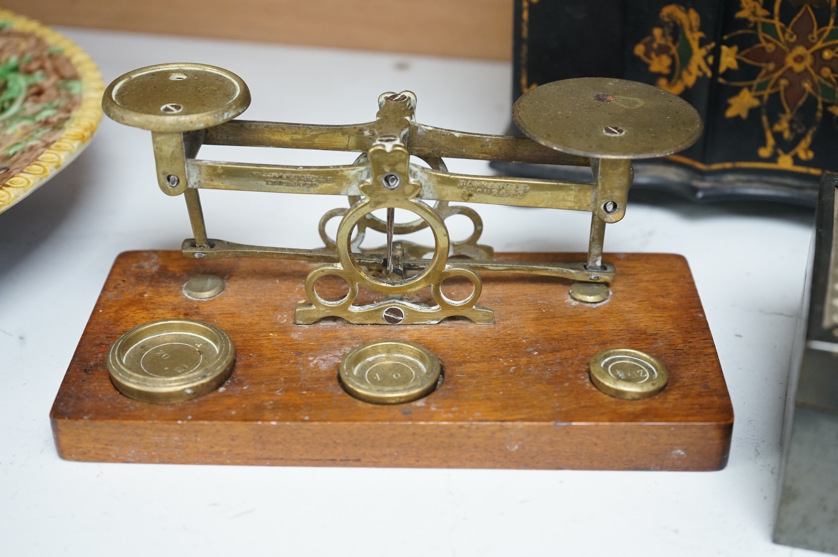 A Victorian papier maché tea caddy, postal scales and a military interest cigarette box, largest 19cm wide